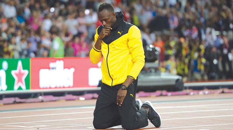 Usain Bolt kneels down during a lap of honour at the end of the World Athletics Championships in London Sunday (Photo: AP)
