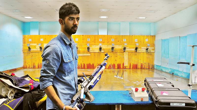 The trainer with the damaged rifle at the shooting  academy which has been severely affected by the rain earlier this week (Photo: SATISH B)
