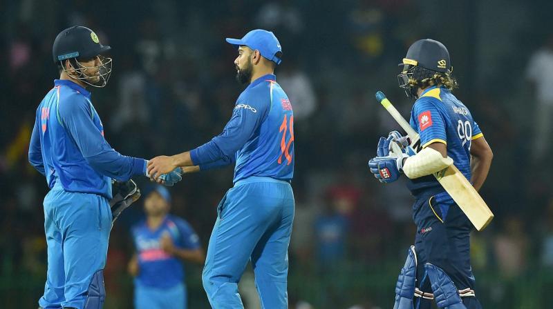 Sri Lankas Lasith Malinga looks on as Indias Virat Kohli and Mahendra Singh Dhoni celebrates after win the match during the 4th ODI match in Colombo, Sri Lanka, on Thursday (Photo: AP)