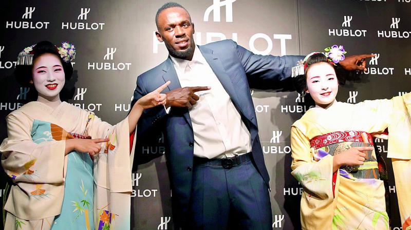 Usain Bolt of Jamaica gestures with maiko, or an apprentice geisha, during a promotional event in Kyoto, western Japan on Tuesday. (Photo: AP)