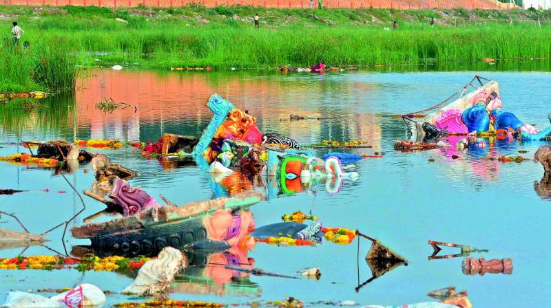 The half-immersed idols of Lord Ganesh make water stink downstream Prakasam barrage in Vijayawada on Wednesday. (Photo: DC)