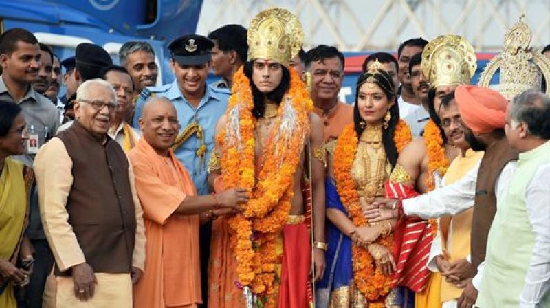 Uttar Pradesh Chief Minister Yogi Adityanath performs Abhishek of artistes dressed up as Lord Rama, Sita and Lakshman during Deepotsav celebrations in Ayodhya on Wednesday. (Photo: PTI)