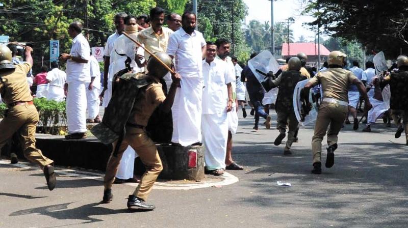 Police chasing Congress workers during the lathicharge in front of Thrissur Collectorate on Friday. Former MLA and Congree leader T.N. Parthapan who was spared by the cops from being beaten up, looks on. (Photo: ANUP K VENU)