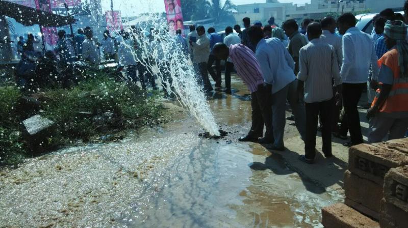 Curious onlookers see water spouting from an old pipeline at Uppal, near the venue of a function to inaugurate a new project, in Hyderabad on Friday.