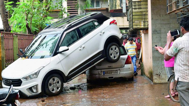 A car is seen piled over another, presumably after being drifted by floodwater during Tuesdays heavy downpour in Mumbai on Wednesday. (Photo: PTI)