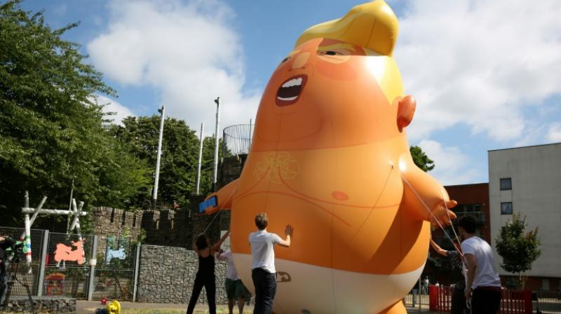 The orange-hued blimp was inflated in Parliament Square at about 9.30 am as a crowd of onlookers cheered. (Photo: AFP)