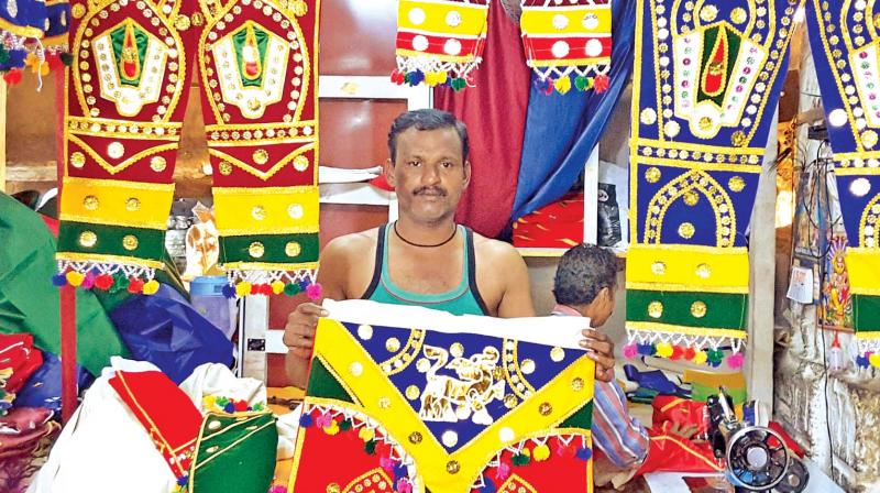 A shop-keeper displays colourful salladam (Alagar dress) at Pudumandapam. (Photo: DC)