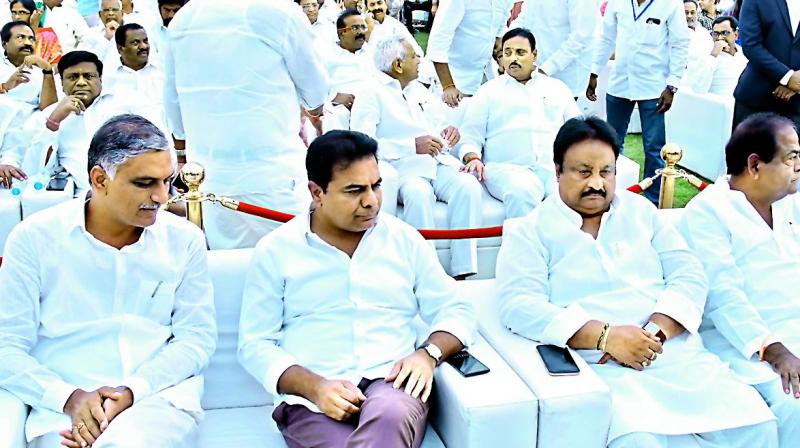 Senior TRS MLA T. Harish Rao and party working president K.T. Rama Rao at the swearing-in ceremony at Raj Bhavan in Hyderabad on Tuesday.