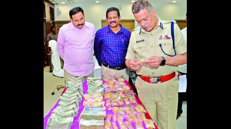 Police commissioner Ch. D. Tirumala Rao look at the seized cash and gold in Vijayawada on Saturday. (Photo: DC)