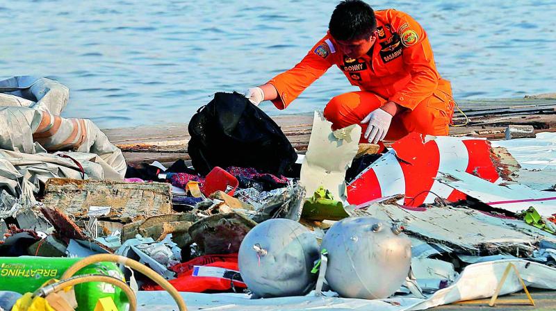 A member of Indonesian Search and Rescue Agency inspects debris believed to be from Lion Air passenger jet that crashed off Java Island at Tanjung Priok Port in Jakarta, Indonesia on Monday.  (AP)