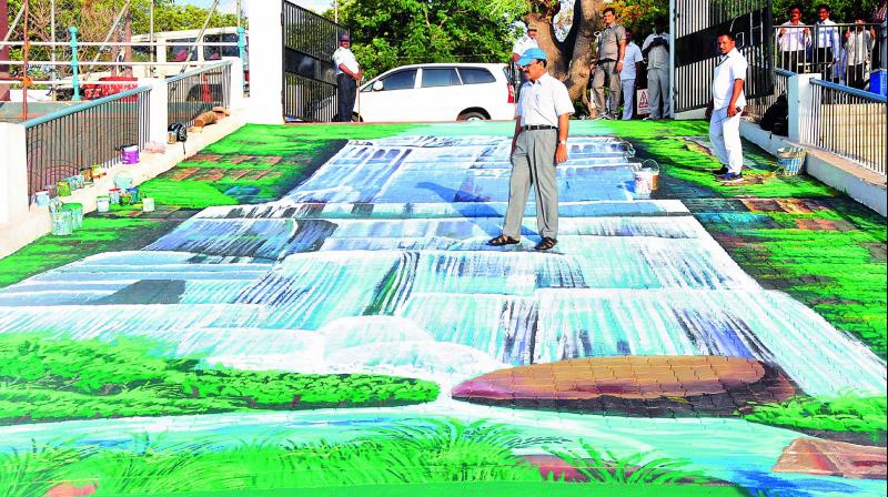 GHMC commissioner Janardhan Reddy looks at a painting at the Bathukamma Ghat on Tank Bund on Monday as the corporation starts 3D painting programme at prominent junctions.