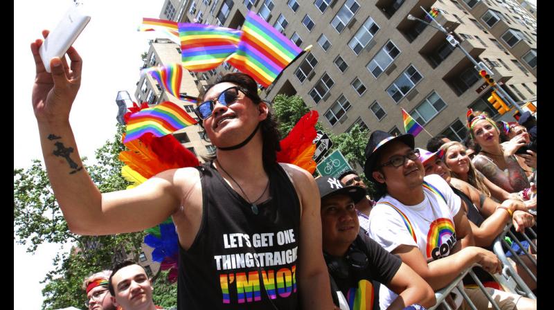Bong Biseo, of the Queens borough of New York, left, and others react as they watch the Gay Pride Parade  (Photo: AP)