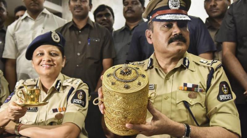 Hyderabad Police Commissioner Anjani Kumar along with a senior police officer shows to media the three-tier golden tiffin box and a golden cup after their recovery. (Photo: PTI)