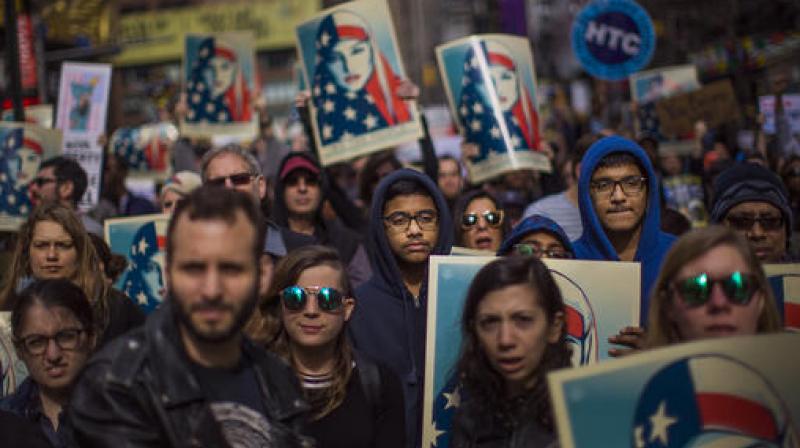 People carry posters during a rally in support of Muslim Americans and protest of President Donald Trumps immigration policies in Times Square, New York. (Photo: AP)