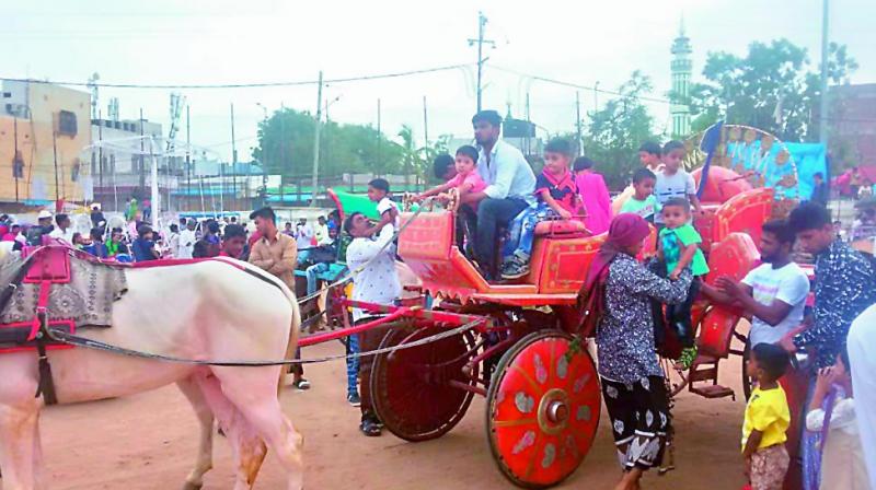Children embark on a chariot ride at the fair organised every year at the Barkas ground in Hyderabad on Saturday.  (Photo:DC)