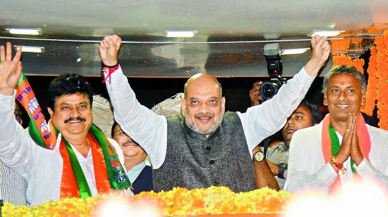 BJP national president Amit Shah participates in a roadshow in Malkajgiri, AS Rao Nagar on Sunday. BJP candidate for Malkajgiri N. Ramachander Rao (left) and Uppal Assembly candidate N.V.S.S. Prabhakar (right) are also seen. (DC)