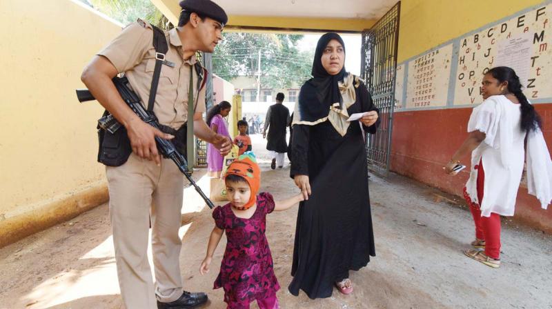 A child accompanies her mother to a polling booth in the city on Saturday 	(Image: DC)