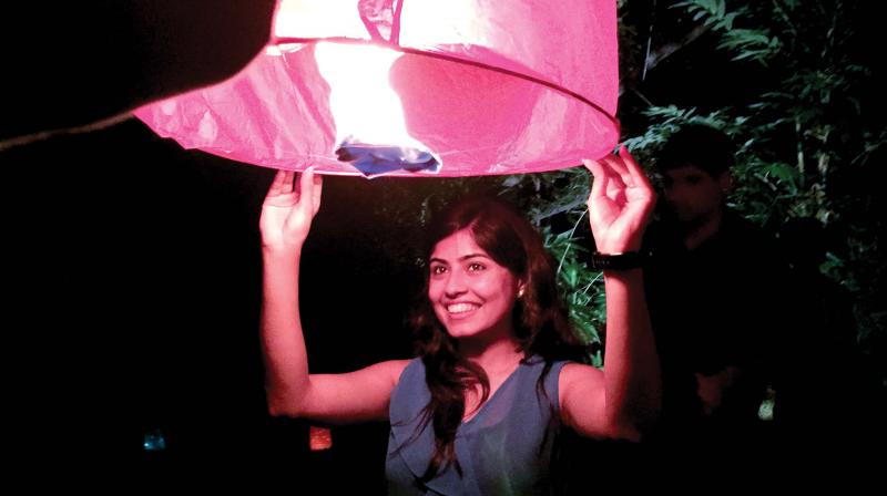 A young lady posing with a sky lantern