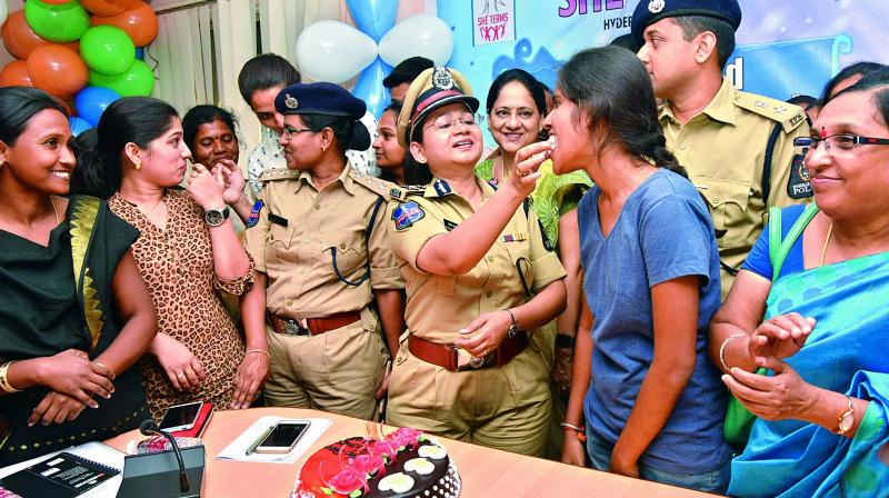 ADGP Swathi Lakra, Addl. CP crimes, Avinash Mohanty and SHE teams personnel mark two years of the force with women the police helped out, on Monday. 	(Photo: DC)