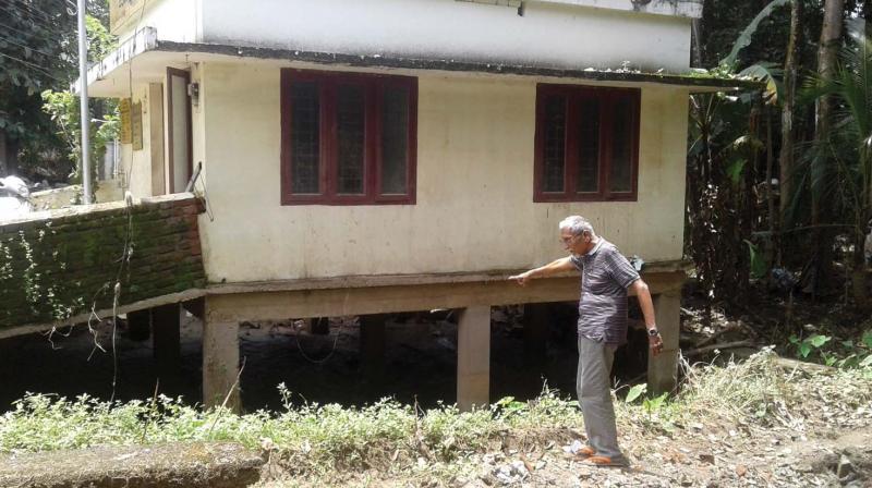 Environmentalist N. Ramachandran points to the encroachment on Onjithodu by building an anganwadi in its original path. (Photo: DC)