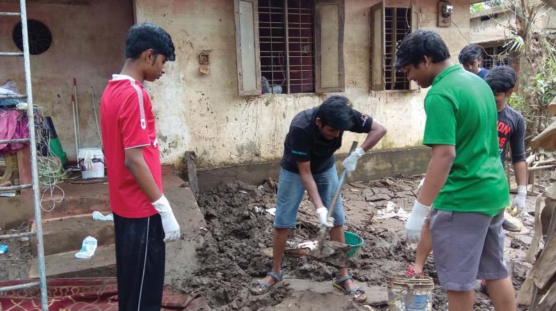 Students of Model Technical Higher Secondary School, Kaloor clean slush at the house of their classmate in Kochi on Saturday.(Photo: DC)