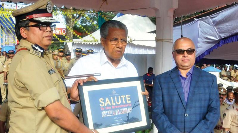 Chief Minister Pinarayi Vijayan hands over a memento to state police chief Loknath Behara in recognition of the police departments exemplary service during the recent floods in the state, in Thiruvananthapuram on Saturday. Chief secretary Tom Jose is also seen. (Photo: A.V.MUZAFAR )