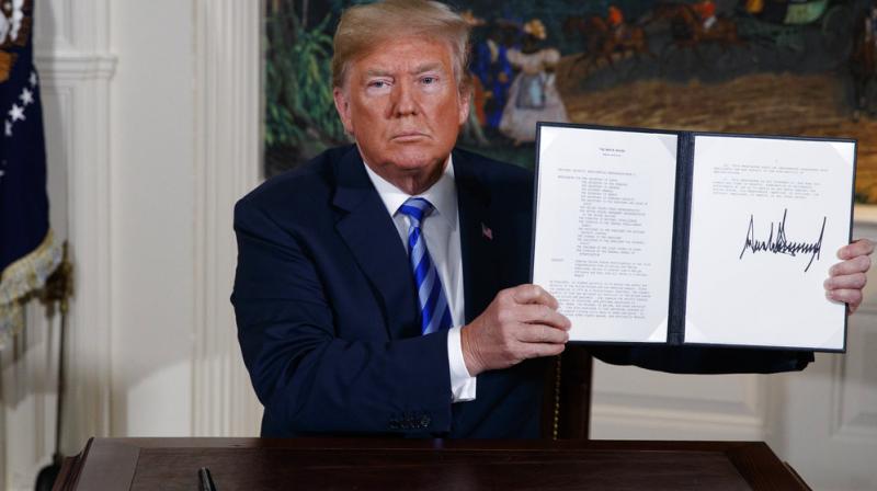 US President Donald Trump shows a signed Presidential Memorandum after delivering a statement on the Iran nuclear deal from the Diplomatic Reception Room of the White House, Tuesday, May 8, 2018, in Washington. (Photo: AP)