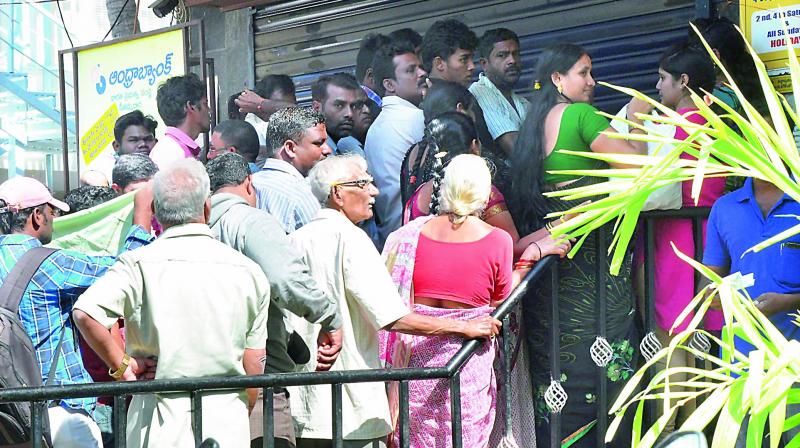 People waiting in front of an ATM that was partially closed at the Andhra Bank main branch at Seethammadhara in Visakhapatnam on Wednesday. (Photo: DC)