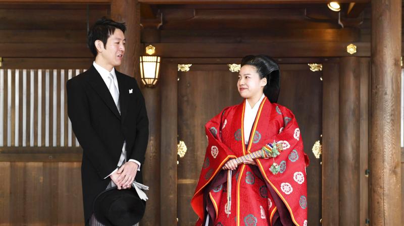 She wore a Heian-era style hairdo and a traditional robe splashed with red and green patterns while Moriya wore coattails.