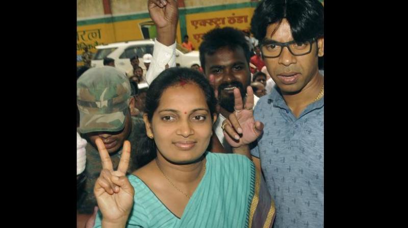 JMM candidate Seema Mahato with her husband Amit Kumar Mahato flash victory sign after winning the Silli constituency seat. (Photo: PTI)