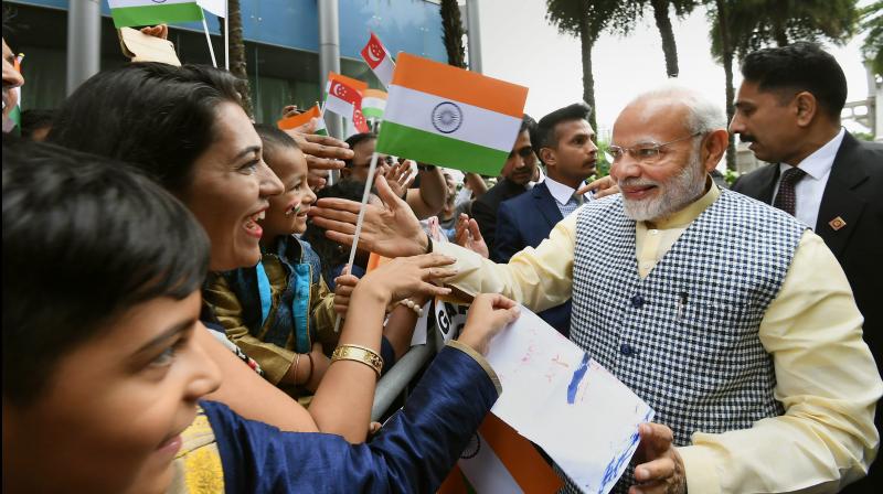 Prime Minister Narendra Modi being greeted by the members of Indian community on his arrival in Singapore on Thursday. (Photo: PTI)