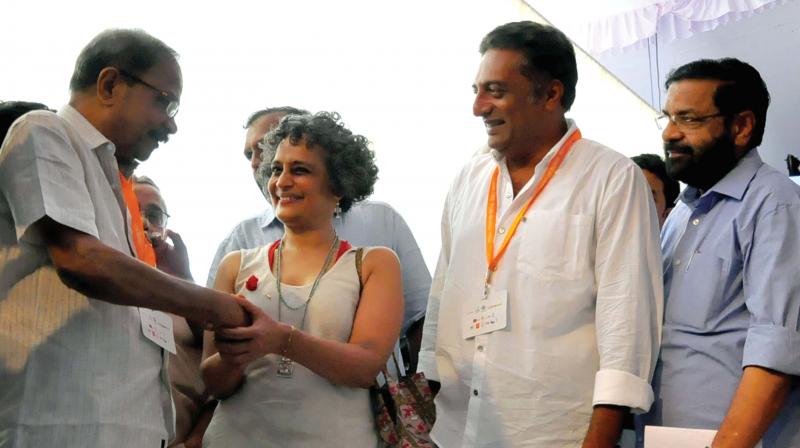 Writer Arundhati Roy greets writer M.T. Vasudevan Nair as actor Prakash Raj looks on, during the inaugural ceremony of Kerala Literature Festival in Kozhikode on Thursday. (Photo: DC)