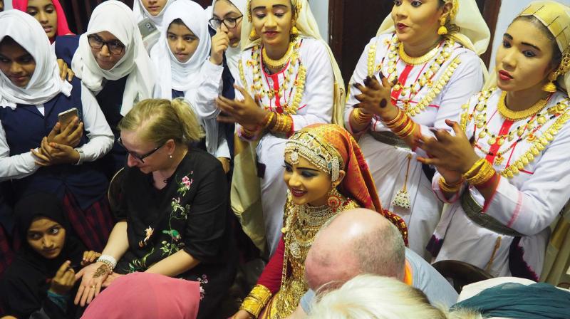 A group of Irish authors, enjoying Mehndi on their hands done by the girls in traditional Oppana costume.