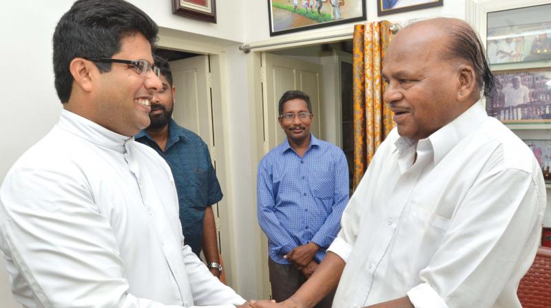 Perumbadavam Sreedharan is greeted by Fr Vincy Varghese, vice-principal of Mar Ivanios College, at the novelists residence at Thamalam in Thiruvananthapuram on Monday. (Photo: Peethambaran Payyeri)