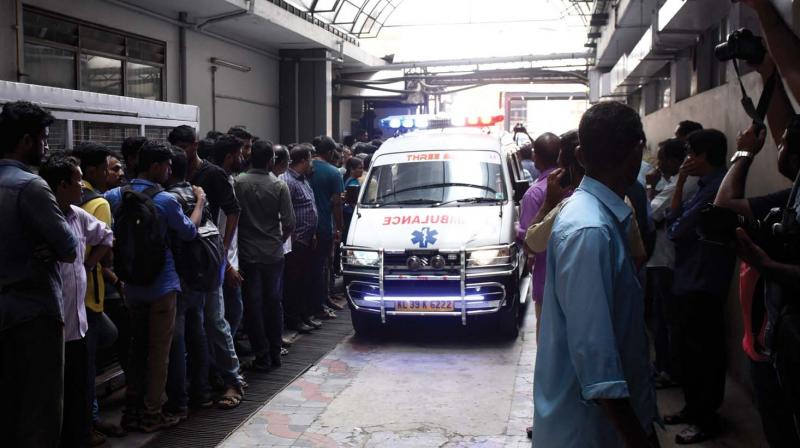 Ambulance carrying the bodies comes out of the Cochin Shipyard on Tuesday morning.