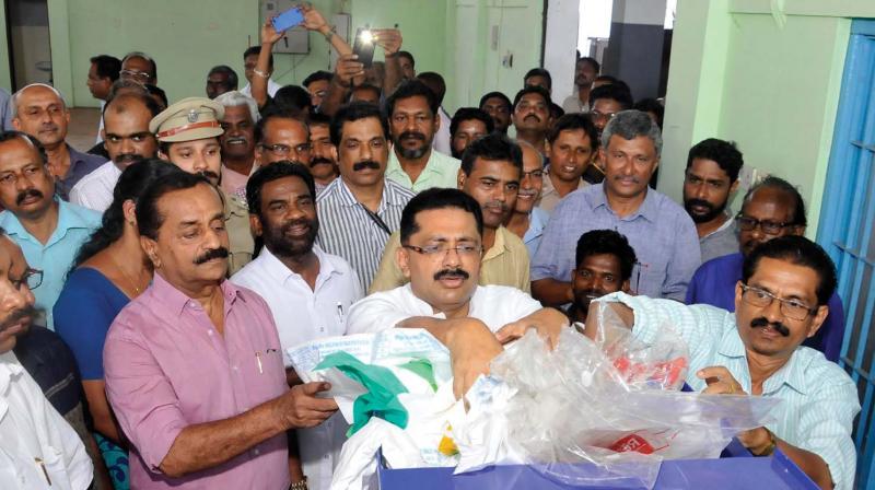 LSG minister K.T. Jaleel puts plastic waste into the shredding machine as part of the inauguration of plastic waste treatment unit at Westhill on Tuesday. (Photo: DC)