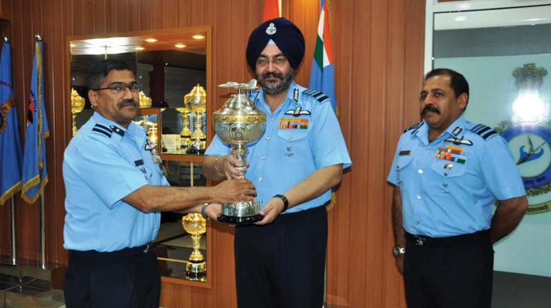 Chief of Air Staff Air Chief Marshal B.S. Dhanoa presents Pride of the Command Trophy to AOC Air Force Station Sulur. AOC-in-C Southern Air Command is also seen. 	BY ARRANGEMENT