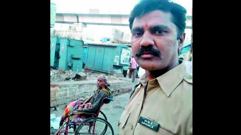 Police constable K. Dhanraj with the 60-year-old wheelchair bound poor man.