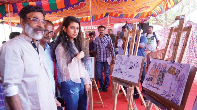 Oru Adar Love fame Priya Varrier watches cartoons  exhibited at Lalitha Kala Akademi in Thrissur on Sunday. 	 (Photo: ANUP K. VENU)