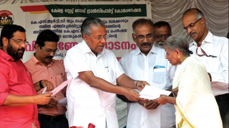 Chief Minister Pinarayi Vijayan distributes pension to Lalithamma of Vattiyurkkavu in presence of Ministers Kadakampalli Surendran, AK Saseendran in Thiruvananthapuram on Tuesday. (Photo: Peethambaran Payyeri)