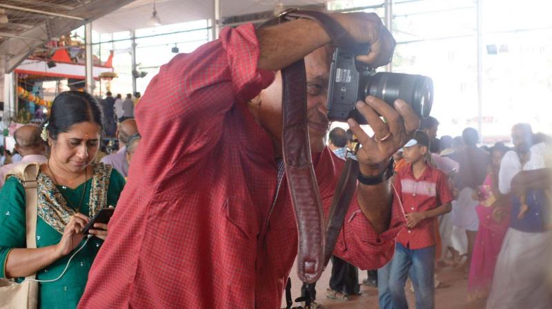 Renowned photographer Raghu Rai takes  pictures of Attukal temple on Friday. Historian Lekshmy Rajeev is also seen.