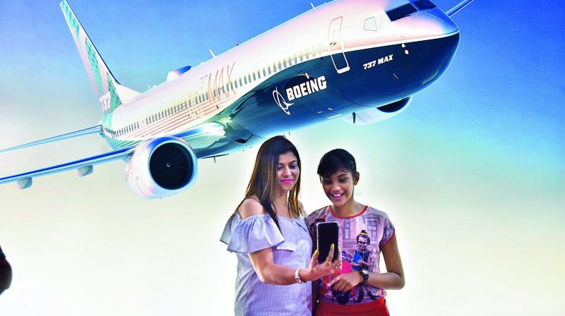 Girls take a selfie in front of a poster of a plane (Photo: DC)