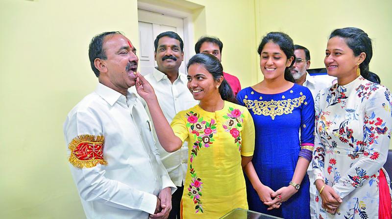 Daughter Netha offers sweet to finance minister Etela Rajender before he leaves to present the TS Budget in the Assembly on Thursday. Daughter-in-law Kshamitha is also seen. 	(Photo: DC)