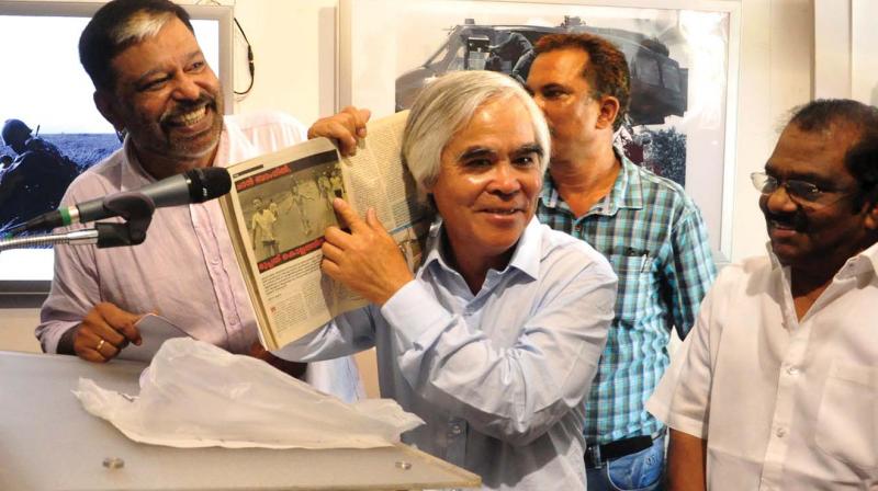 Nick Ut points at his photograph published  in a Malayalam magazine during the exhibition at Art Gallery. Writer of the article Vinod Krishnan Purushan Kadalundi MLA is also seen. (Photo: DC)