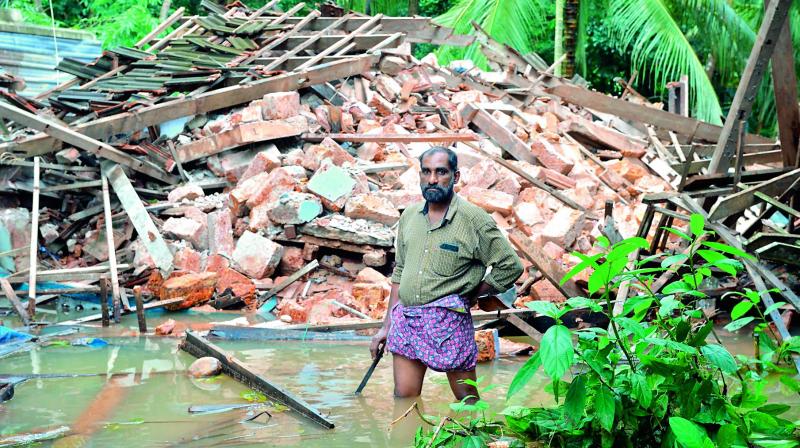 A man stands in front of the rubble of his house on the outskirts of Kozhikode district,  on Friday. (Photo: AFP)