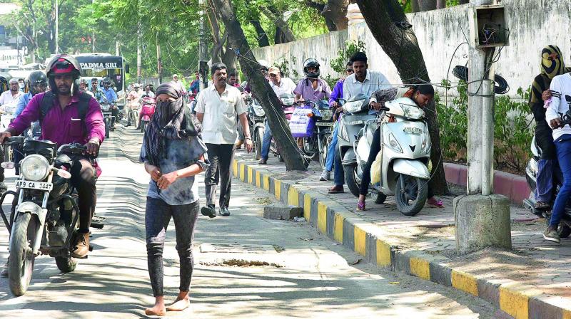 Pedestrians forced to walk on the road as two-wheelers were riding on the footpath. (Photo: File Photo)