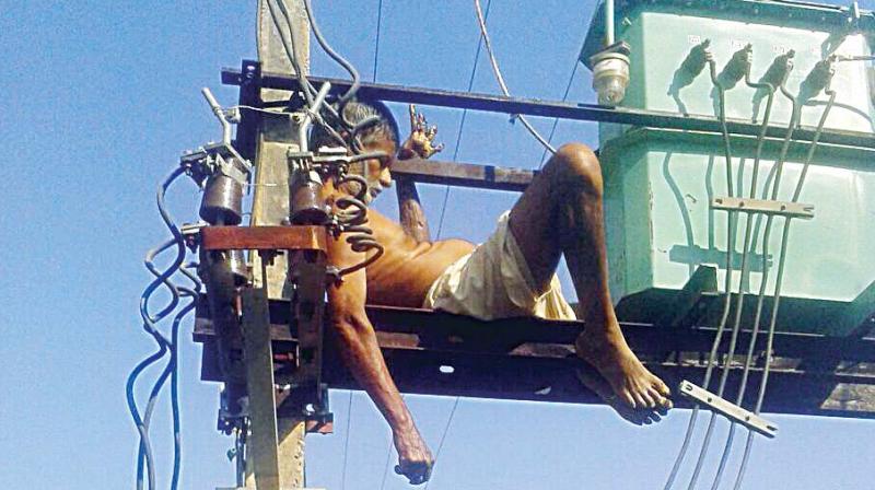 The body of Chamansab Arisinaguppi  of Hangal taluk atop a transformer.