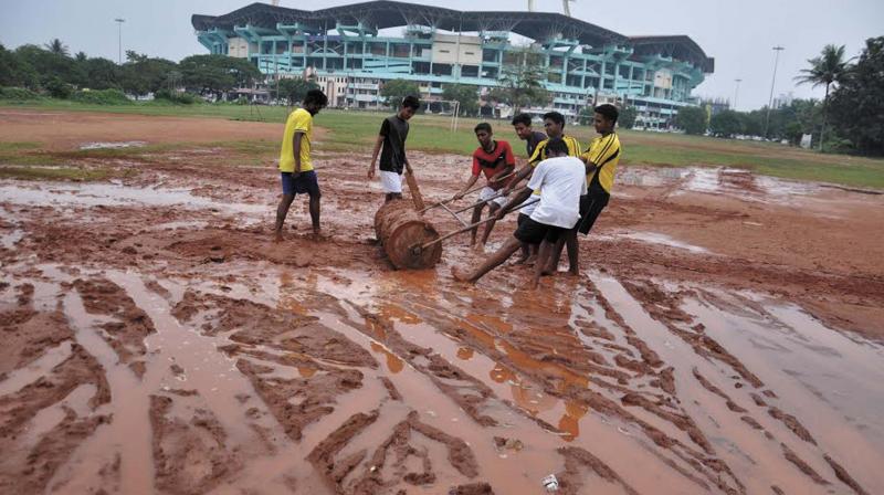 St. Alberts College players pull a roller on the college ground in the vicinity of the Jawaharlal Nehru Stadium that turned slushy after being used for parking during the ISL matches in Kochi, on Thursday. (Photo: DC)