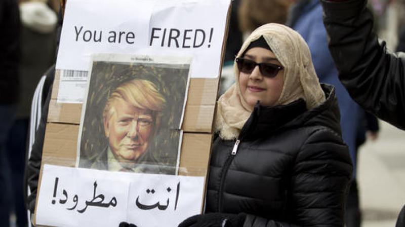 A woman carries a sign outside of the White House during a demonstration to denounce President Donald Trumps executive order that bars citizens of seven predominantly Muslim-majority countries from entering the US. (Photo: AP)