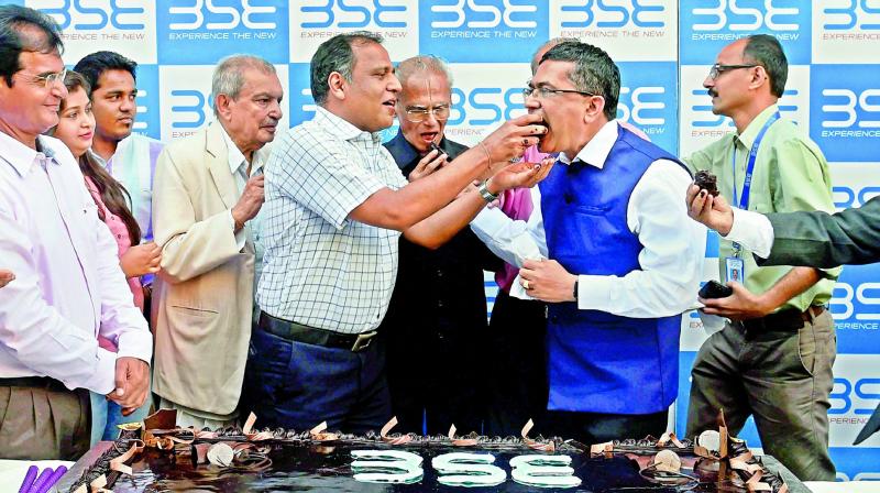 People celebrate with a 30 kilogram cake at the Bombay Stock Exchange as the Sensex hits 30,000 mark in Mumbai on Wednesday. (Photo: PTI)
